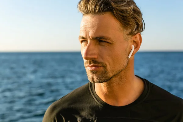 Close Portrait Handsome Adult Man Wireless Earphones Seashore Looking Away Стоковая Картинка