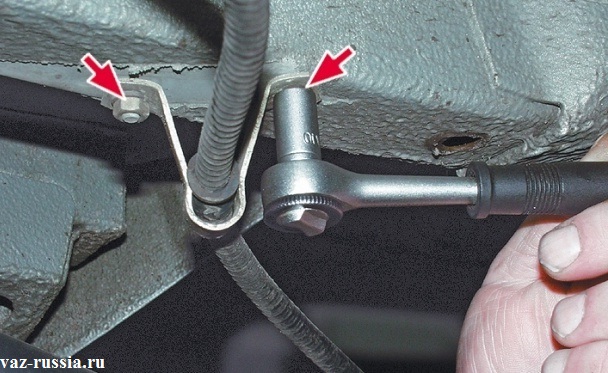 Отворачивание двух гаек крепления кронштейна который придерживает трос стояночного тормоза